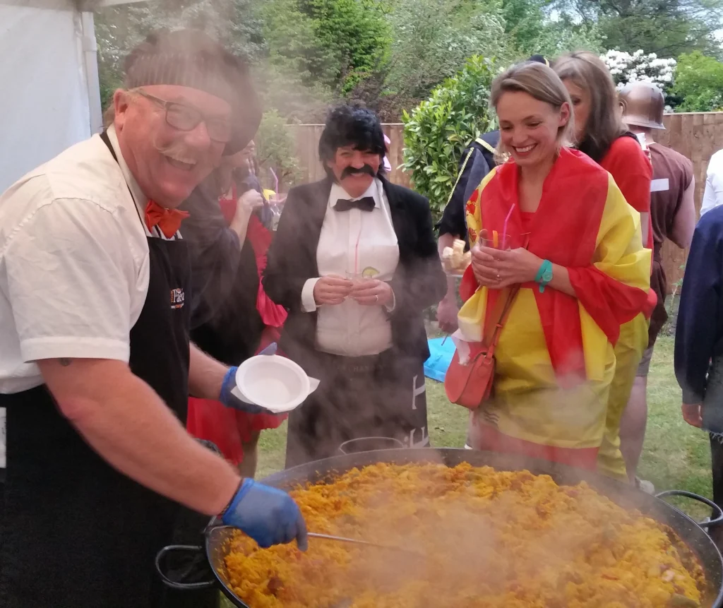 Guests enjoying freshly cooked paella at a private party catered by Your Paella